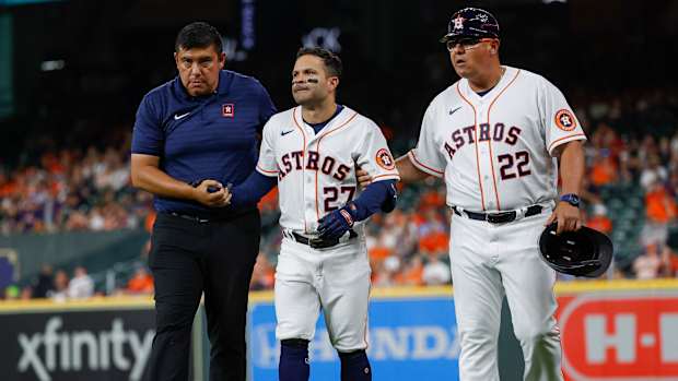 An injured Jose Altuve walks off the field.
